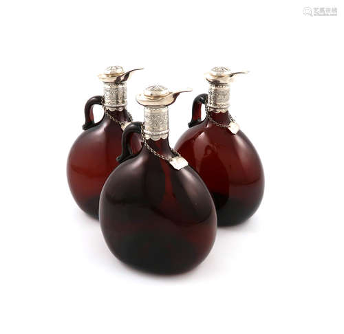 A set of three Victorian silver-mounted brown glass spirit decanters, the mounts by Henry Atkin,