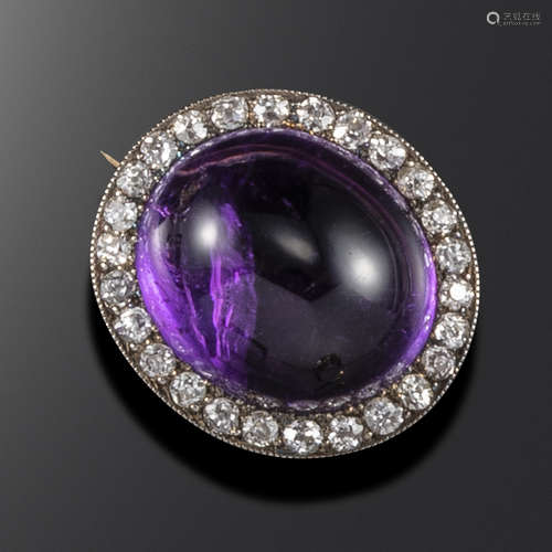 A late Victorian amethyst and diamond brooch, set with an oval amethyst cabochon and a border of old