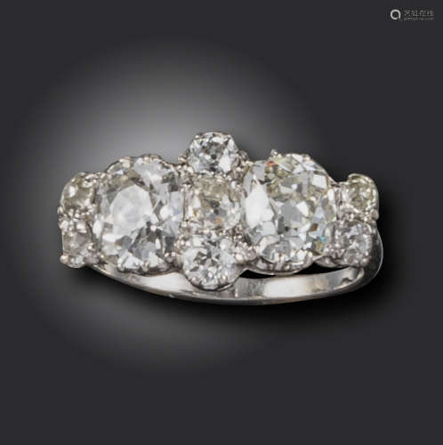 A diamond cluster ring, set with two old cushion-shaped diamonds with old circular-cut diamond