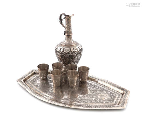 A Persian metalware ewer, six tot cups and a tray, the ewer of baluster form, chased foliate