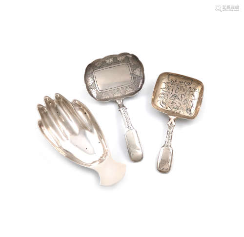 A small collection of three silver caddy spoons, comprising: one modelled as a hand, by F. Howden,