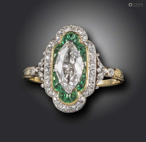 An Edwardian emerald and diamond ring, the marquise-shaped diamond is set within surrounds of