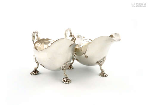 A pair of silver sauce boats, by M. Rhodes, London 1930, oval form, wavy-edge border, scroll handle,