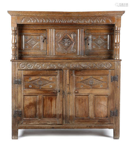 A CHARLES II OAK PRESS CUPBOARD SECOND HALF 17TH CENTURY in two halves, carved with lunettes,