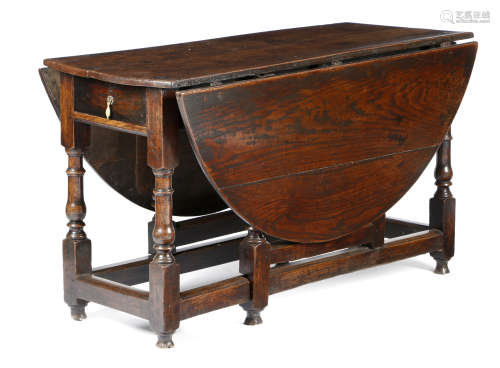 A QUEEN ANNE OAK GATELEG TABLE EARLY 18TH CENTURY the oval drop-leaf top above a single end frieze