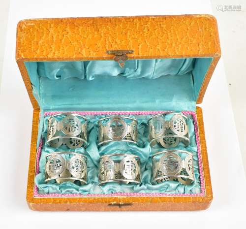 TIEN SHING; a cased set of late 19th century Chinese Export silver napkin rings, all featuring