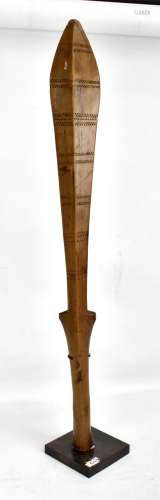 A Tongan club with bands of incised decoration, mounted on a stand, height 80cm.