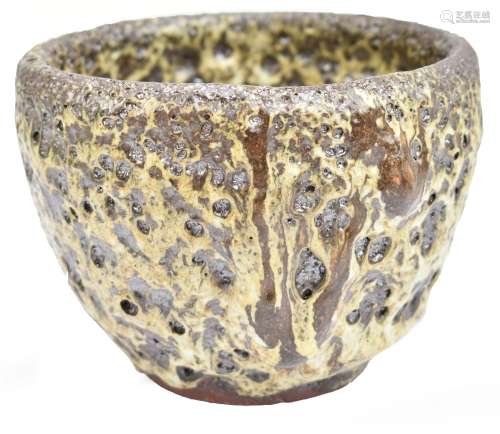 A Japanese earthenware bowl with thick cream and brown eruption glaze, three character mark to base,