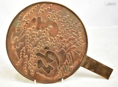 A late 19th/early 20th century Chinese 'magic' bronze mirror with landscape featuring two cranes,