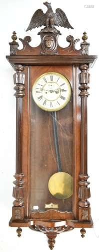 An early 20th century stained walnut cased Vienna style wall clock, with carved eagles surmount, the