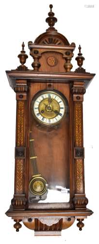 An early 20th century Vienna type wall clock with pen work side panels, the circular dial set with