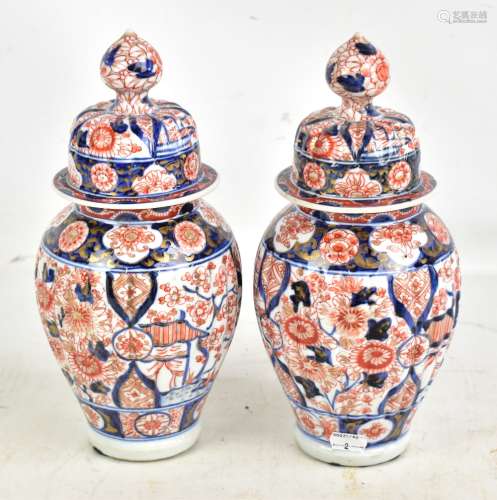 A pair of Japanese Meiji period Imari ribbed lidded vases with underglaze and gilt floral