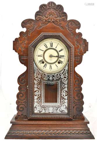 ANSONIA CLOCK COMPANY OF NEW YORK; a stained oak cased gingerbread mantel clock, the circular dial