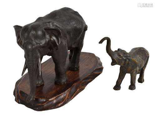 A Japanese Meiji period bronze figure of an elephant raised on an associated wooden stand, unsigned,
