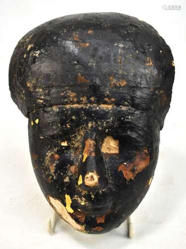 An Egyptian cartonnage funerary mask, with linen, gesso and gold leaf under pitch, height 21.5cm.