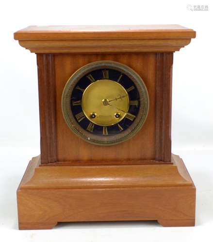 A late 19th/early 20th century mantel clock, the circular dial set with gilt Roman numerals, the