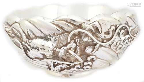 A late 19th/early 20th century Japanese double-skinned silver bowl featuring dragon amongst waves in
