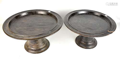 Two African circular tribal stands with dish tops and ring turned trumpet bases, diameter 52cm and