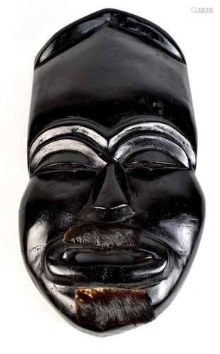 A large Japanese noh mask with animal hide detail and ebonised finish, length 67cm.