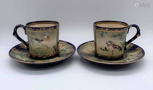 KINKOZAN; a pair of Japanese Meiji period cups and saucers decorated with birds and floral sprays on