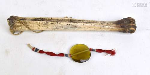 An animal bone drilled with suspension loop, length 27.5cm, and a glass pendant with silk band (