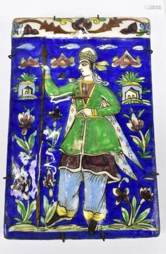 A 19th century Persian Qajar ceramic tile featuring a single figure holding a spear amongst floral