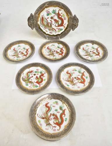 An Oriental porcelain part dinner set decorated in gilt and enamels with dragons chasing the
