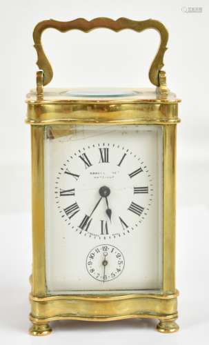 An early 20th century French brass cased carriage clock of shaped outline, the circular dial set