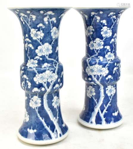 A pair of late 19th/early 20th century Chinese blue and white Gu vases, each painted with prunus