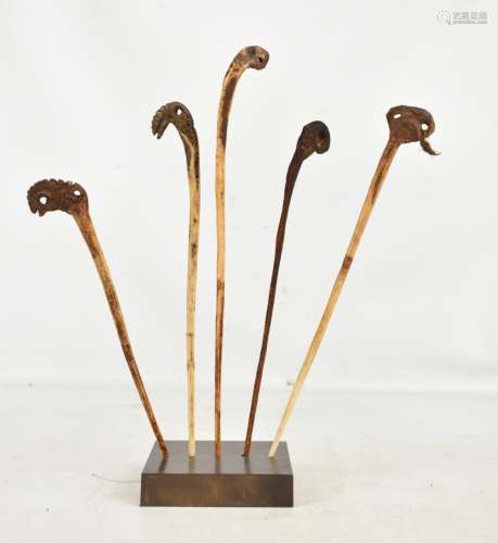 Five Papua New Guinea Iatmul cassowary bone lime spatulas, now mounted in a stand, height approx