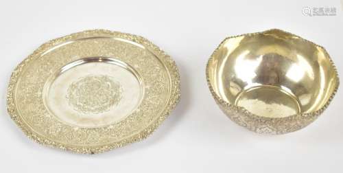 An early 20th century Persian silver bowl and plate, both with cast foliate rims and bright cut