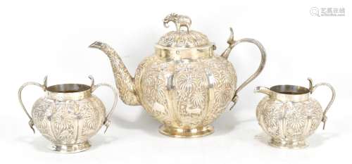 An Indian white metal three piece tea service, each piece with serpent handles and repoussé