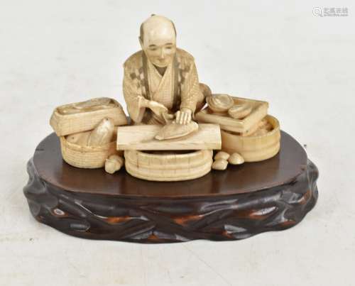 A Japanese Meiji period carved ivory okimono depicting a fishmonger, signed to base, height 7cm,