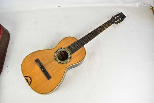 An early 20th century six string acoustic guitar with inlaid and mother of pearl decoration, cased.