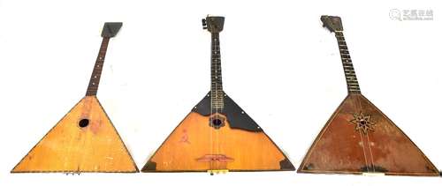 A cased balalaika and two others, one with back decorated with scene of Leningrad (3).