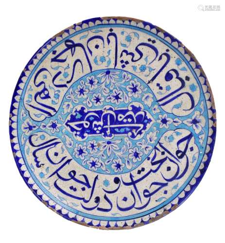 A 19th century Turkish Iznik-style earthenware cobalt glazed charger decorated with floral scrolls