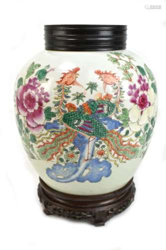 A late 19th century Chinese porcelain ginger jar painted in enamels with two phoenix amongst flowers