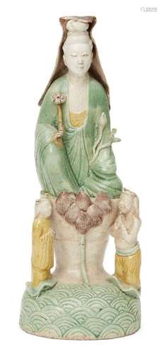 A Chinese biscuit porcelain sancai Guanyin figure group, Kangxi period, modelled as Guanyin seated