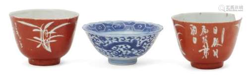 A Chinese porcelain bowl and two reverse-decorated cups, late Qing dynasty, the bowl painted in