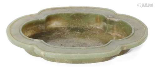 A Chinese spinach jade quatrefoil dish, late Qing dynasty, with flattened grooved rim and four short