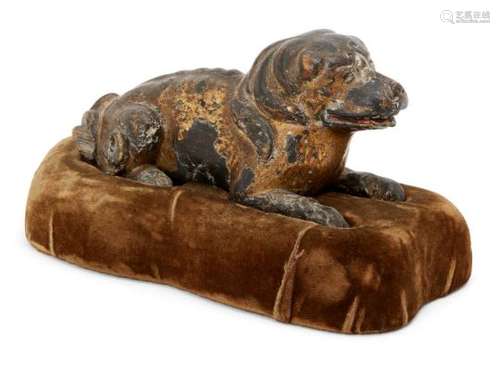 A Chinese parcel gilt carved wood dog, 17th/18th century, carved in recumbent pose with mouth