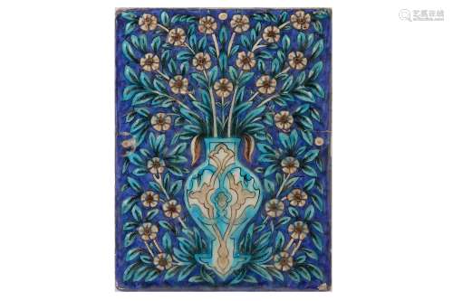 * A QAJAR MOULDED POTTERY TILE WITH FLORAL MOTIF