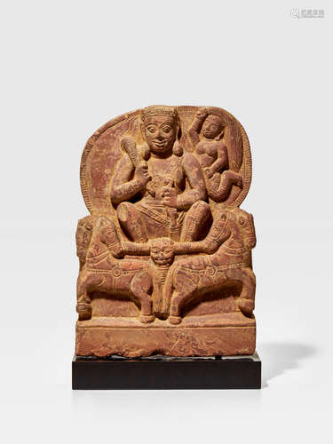 A KUSHAN MOTTLED RED SANDSTONE VOTIVE IMAGE OF SURYA MATHURA, KUSHAN PERIOD, CIRCA 2ND CENTURY