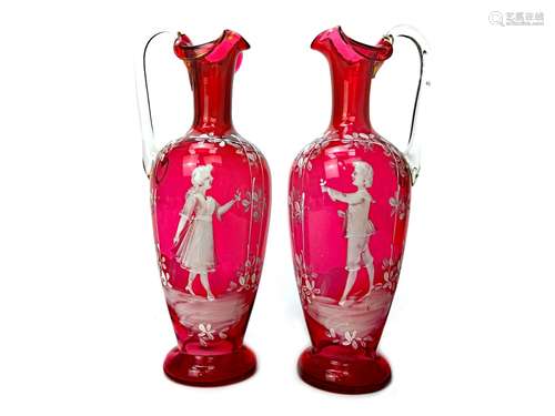 A PAIR OF VICTORIAN 'MARY GREGORY' STYLE CRANBERRY GLASS EWERS