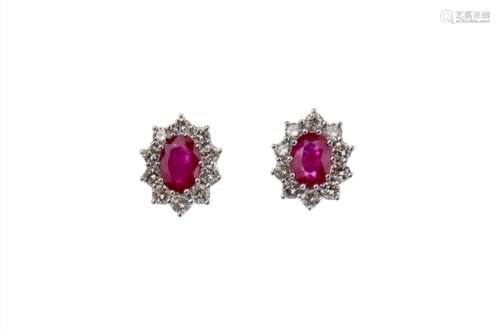 PAIR OF RUBY AND DIAMOND EARRINGS, each set with an oval ruby within a halo of round brilliant cut