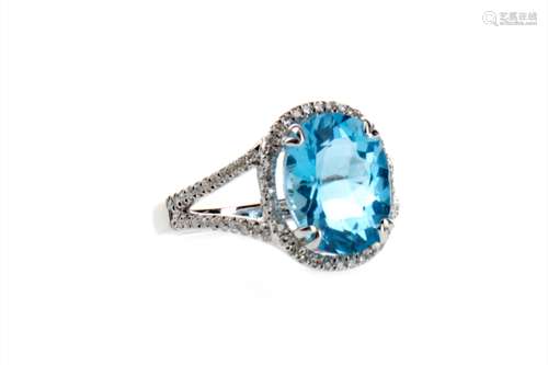 TOPAZ AND DIAMOND RING, the oval topaz 12mm long, within a halo of round brilliant cut diamonds,