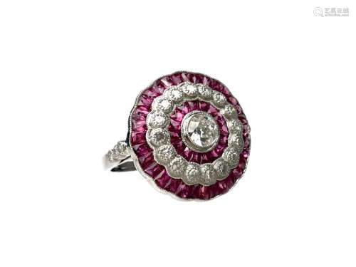 RUBY AND DIAMOND RING, the bezel 19mm in diameter, set with a central round brilliant cut diamond of
