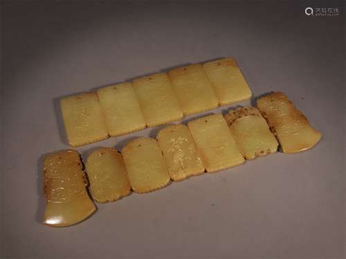 A SET OF QING DYNASTY CARVED YELLOW JADE PENDANTS