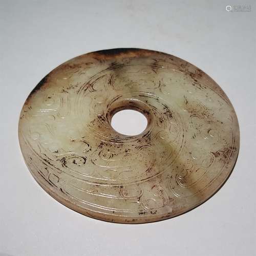 A WARRING STATES PERIOD CARVED WHEEL JADE