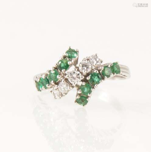 An emerald and diamond crossover ring.